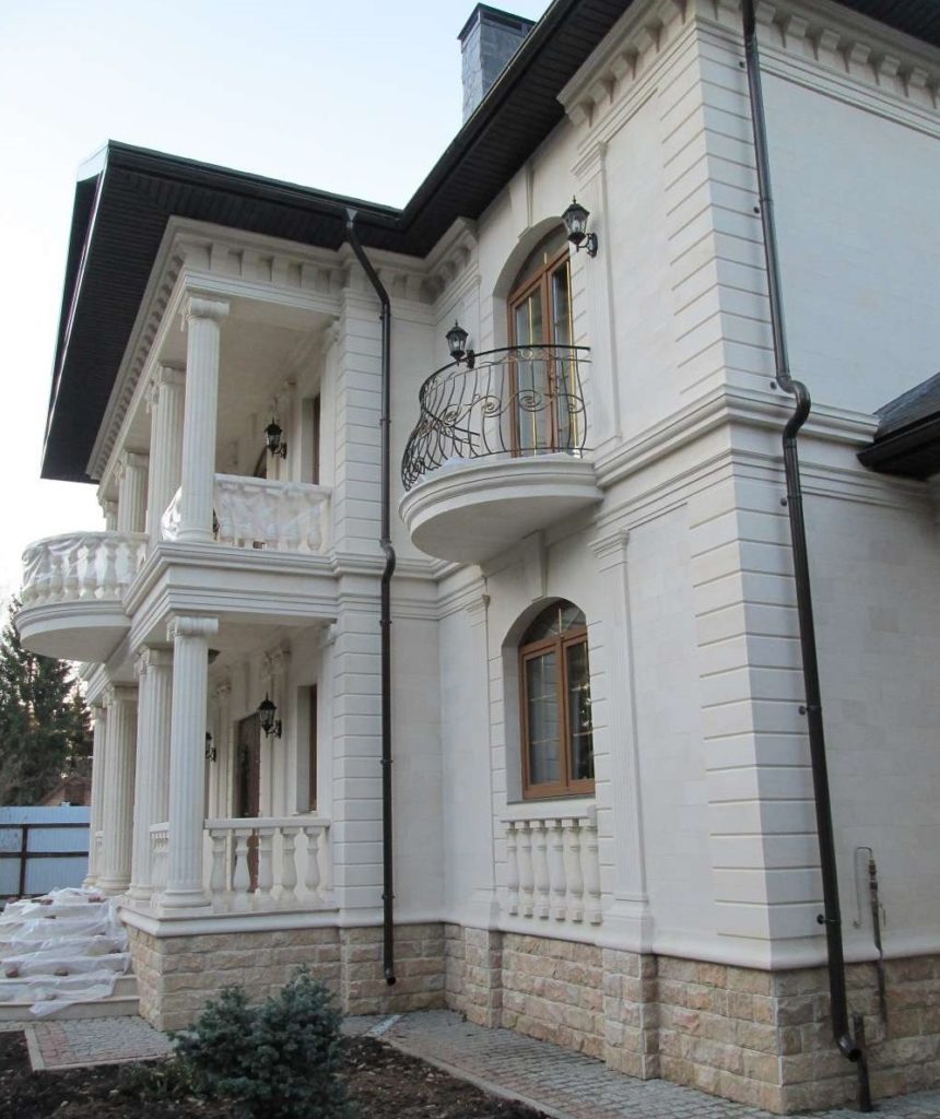 Дом с балконом облицованный плиткой и элементами декора из Акушинского известняка На цоколе Мекегинский доломит